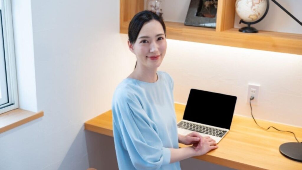 笑顔でパソコン作業をする若い女性