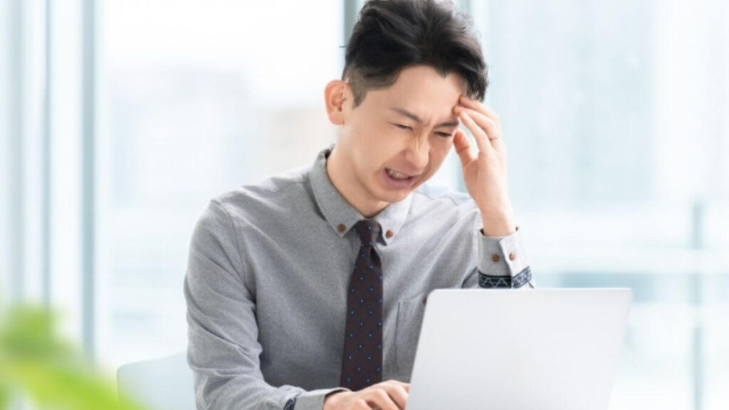 ストレスを抱えながら仕事をするスーツ姿の男性