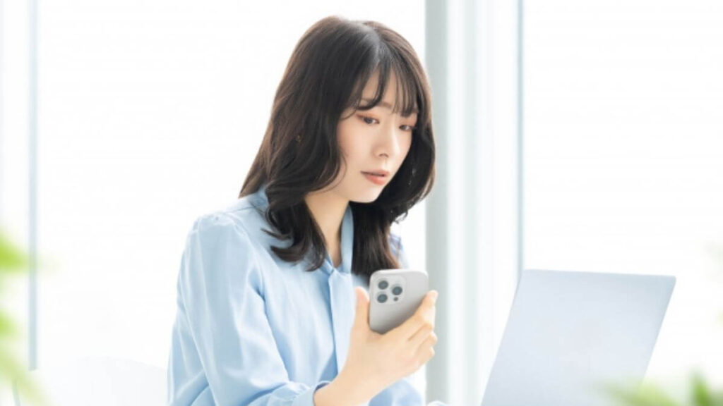 職場で困った表情で仕事をこなす若い女性