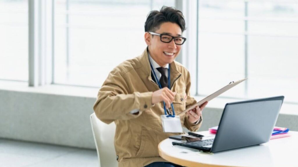 職場で笑顔で仕事をこなす若い男性