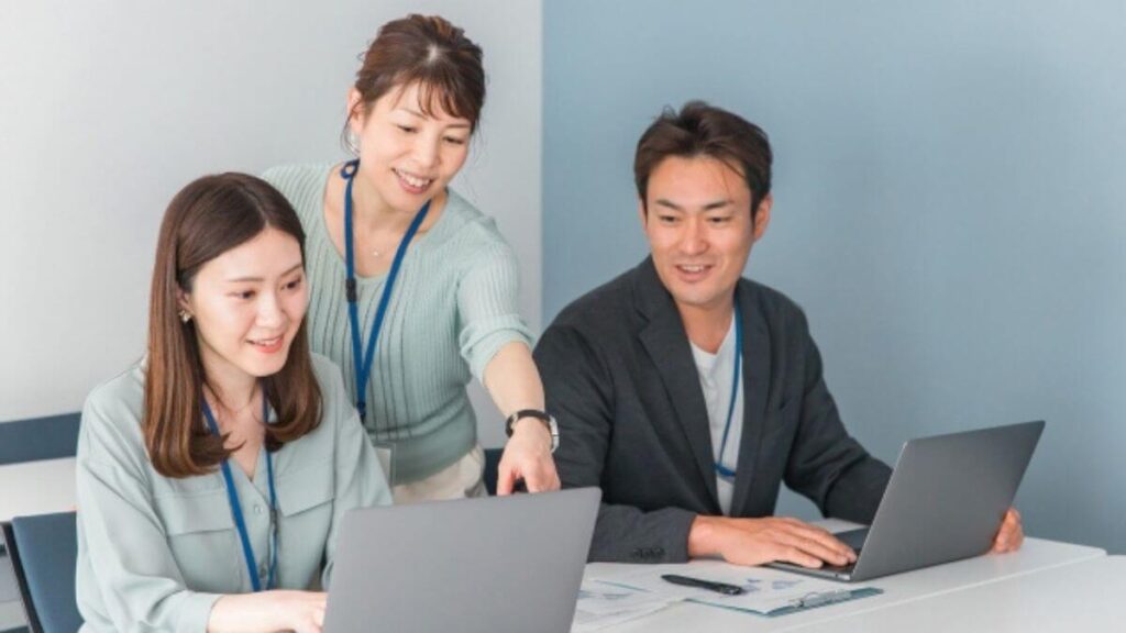 相談しながら仕事をする男女3人