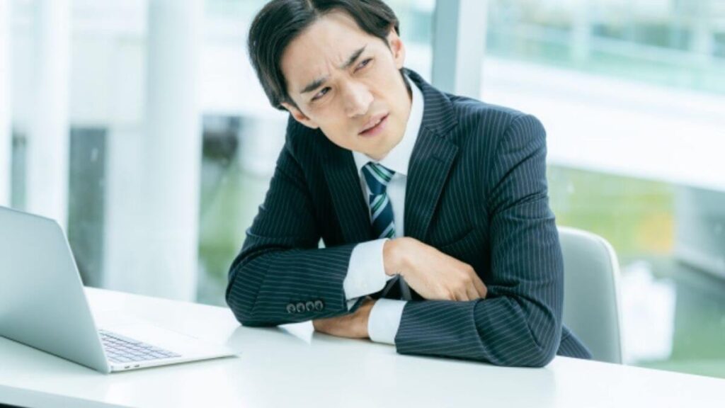 睨みつけるスーツ姿の若い男性