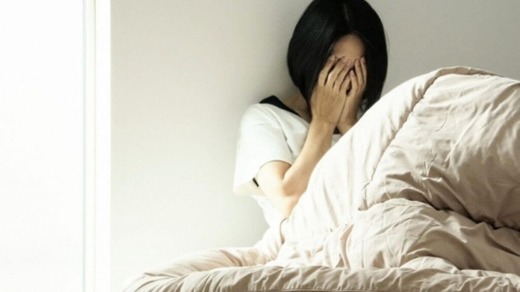 室内で落ち込む若い女性