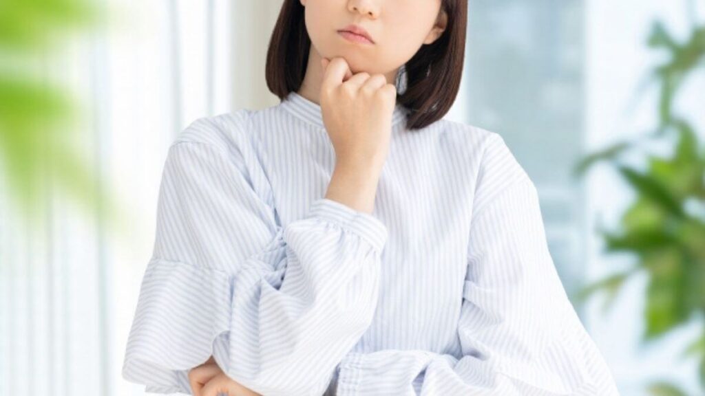 考えるポーズをする若い女性