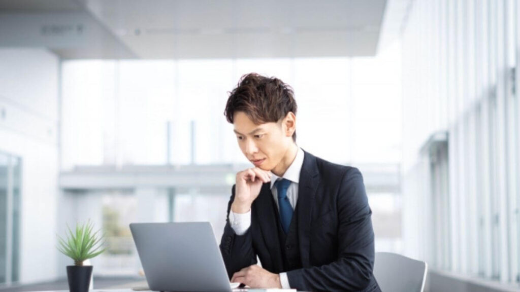スーツ姿で考える中年の男性