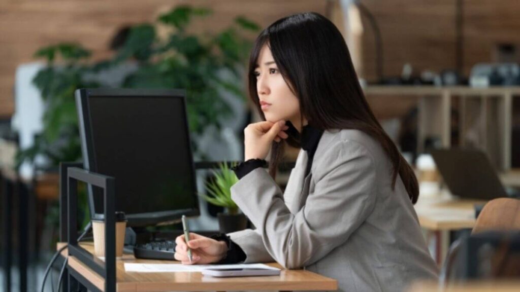 仕事中に悩むスーツ姿の若い女性