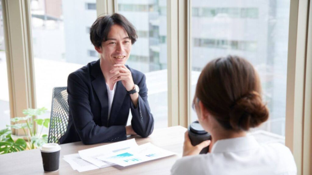 コーヒーを飲みながら職場で雑談する男女