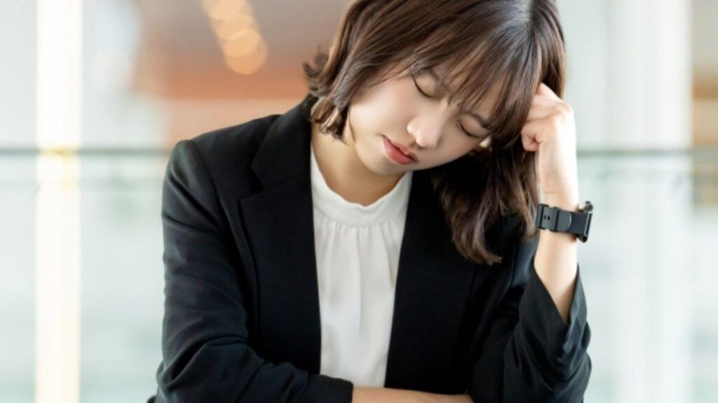 悩むスーツ姿の若い女性